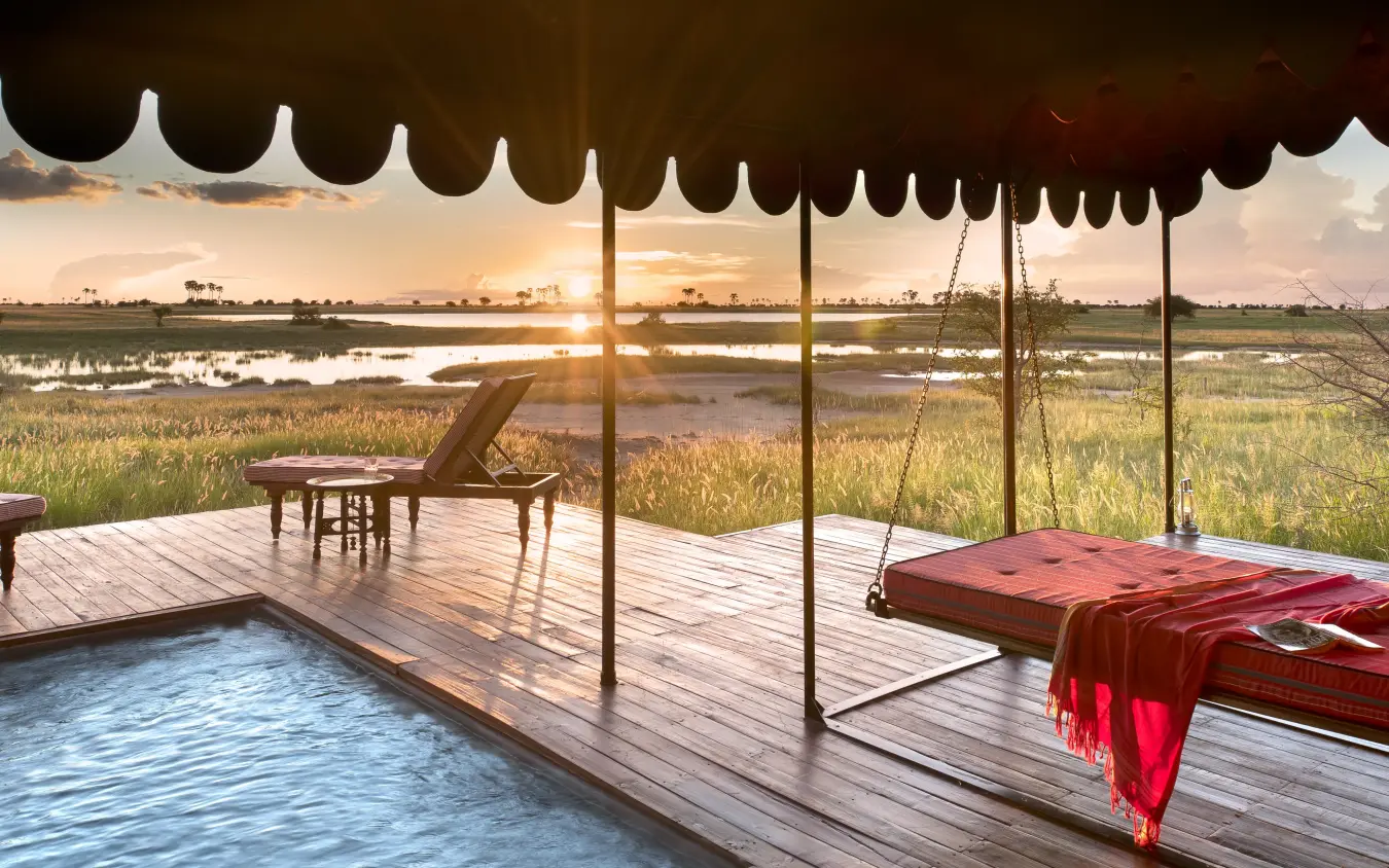 Wooden deck with pool overlooking wetland landscape at sunset, Jack’s Camp, Makgadikgadi Pans, Botswana
