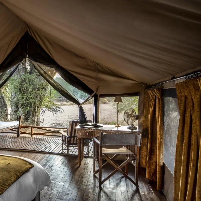 Safari tent interior with bed and lounge seating area, Jongomero Camp, Ruaha National Park, Tanzania