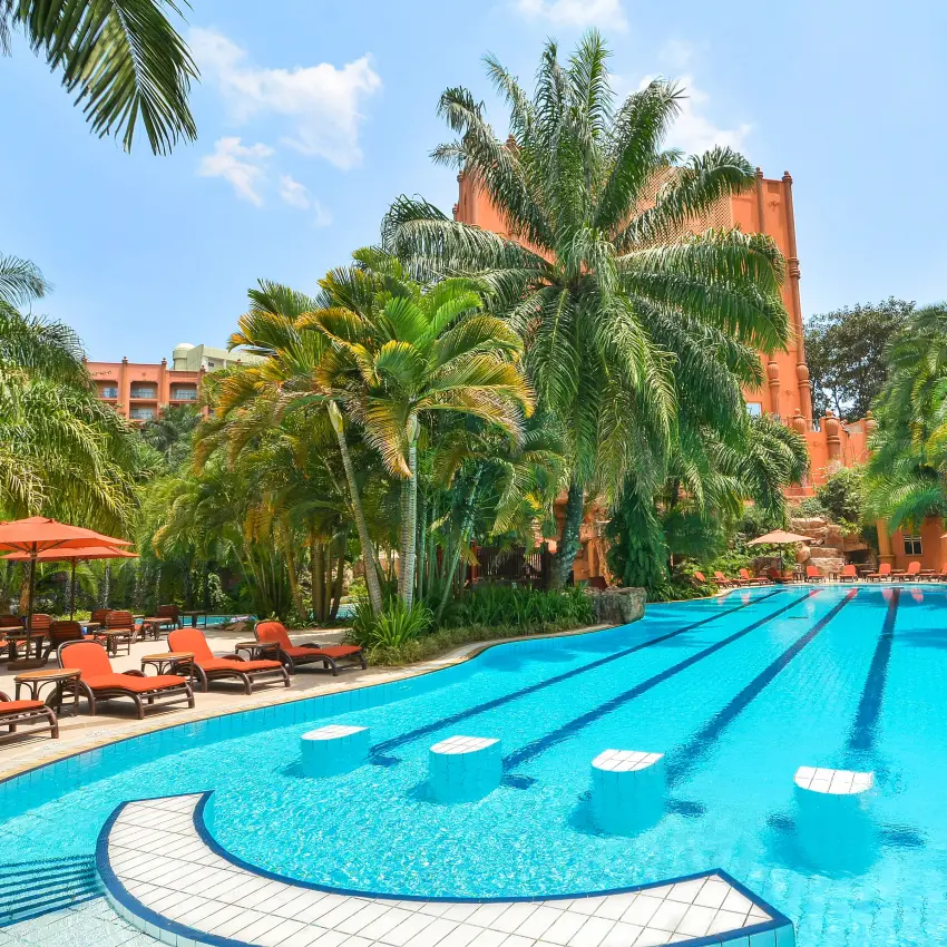 Resort swimming pool with palm trees and terracotta architecture, Kampala Serena Hotel, Entebbe and Kampala, Uganda