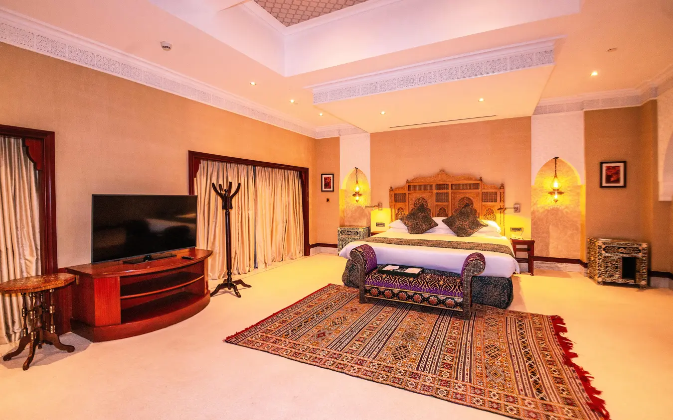 Luxury suite with ornate bed, warm lighting and traditional patterned rug, Kampala Serena Hotel, Entebbe and Kampala, Uganda