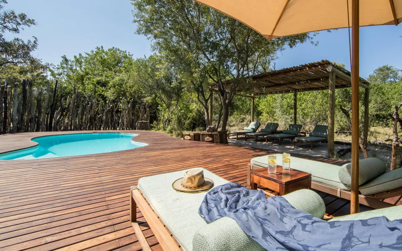 Wooden deck with pool and shaded lounge area surrounded by trees, Kanana, The Okavango Delta, Botswana