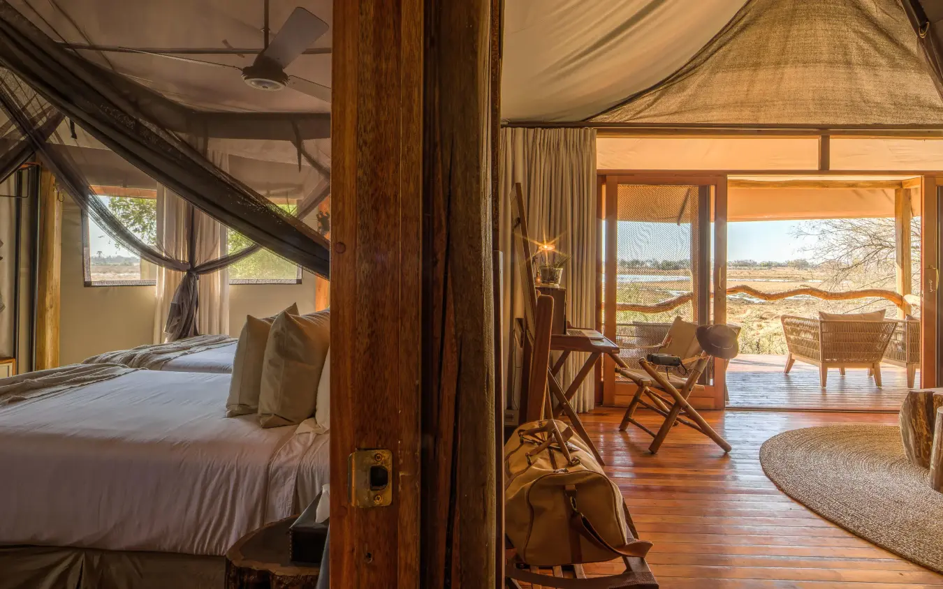 Bedroom with wooden posts and expansive savanna views, Kanana, The Okavango Delta, Botswana