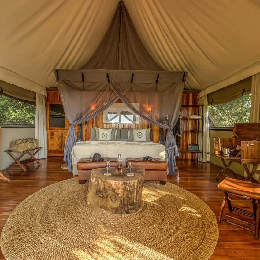Luxury safari tent bedroom with four-poster bed and canvas interior, Kanana, The Okavango Delta, Botswana