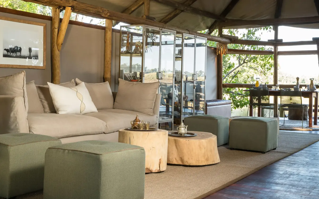Modern lounge with wooden beams and expansive windows overlooking landscape, Kanana, The Okavango Delta, Botswana