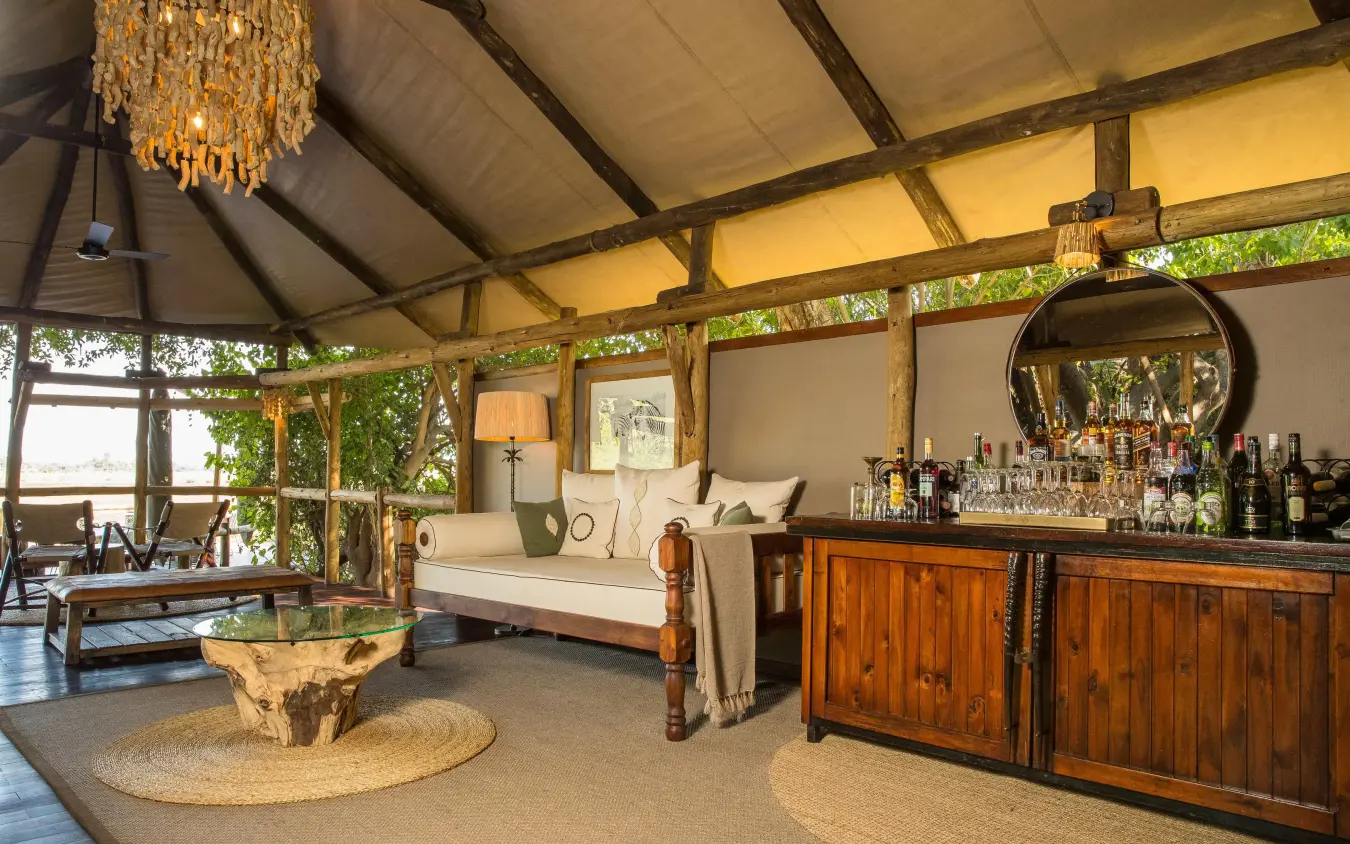 Open-air lounge with wooden bar and guest seating area, Kanana, The Okavango Delta, Botswana
