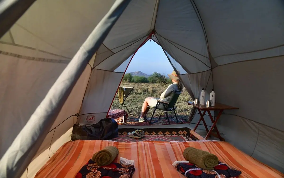 Interior view of safari tent with bedding and mountain vista, Karisia Walking Safaris, Laikipia Highlands, Kenya