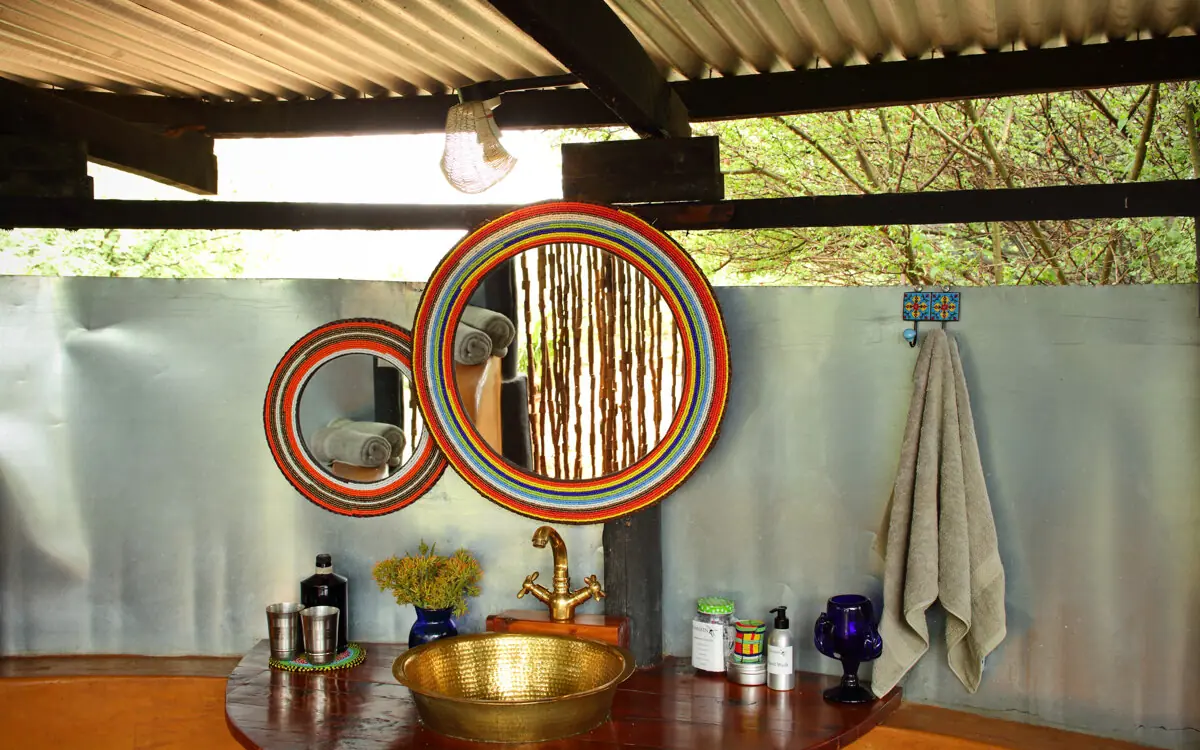 Outdoor bathroom with gold sink bowl and decorative mirrors, Karisia Walking Safaris, Laikipia Highlands, Kenya