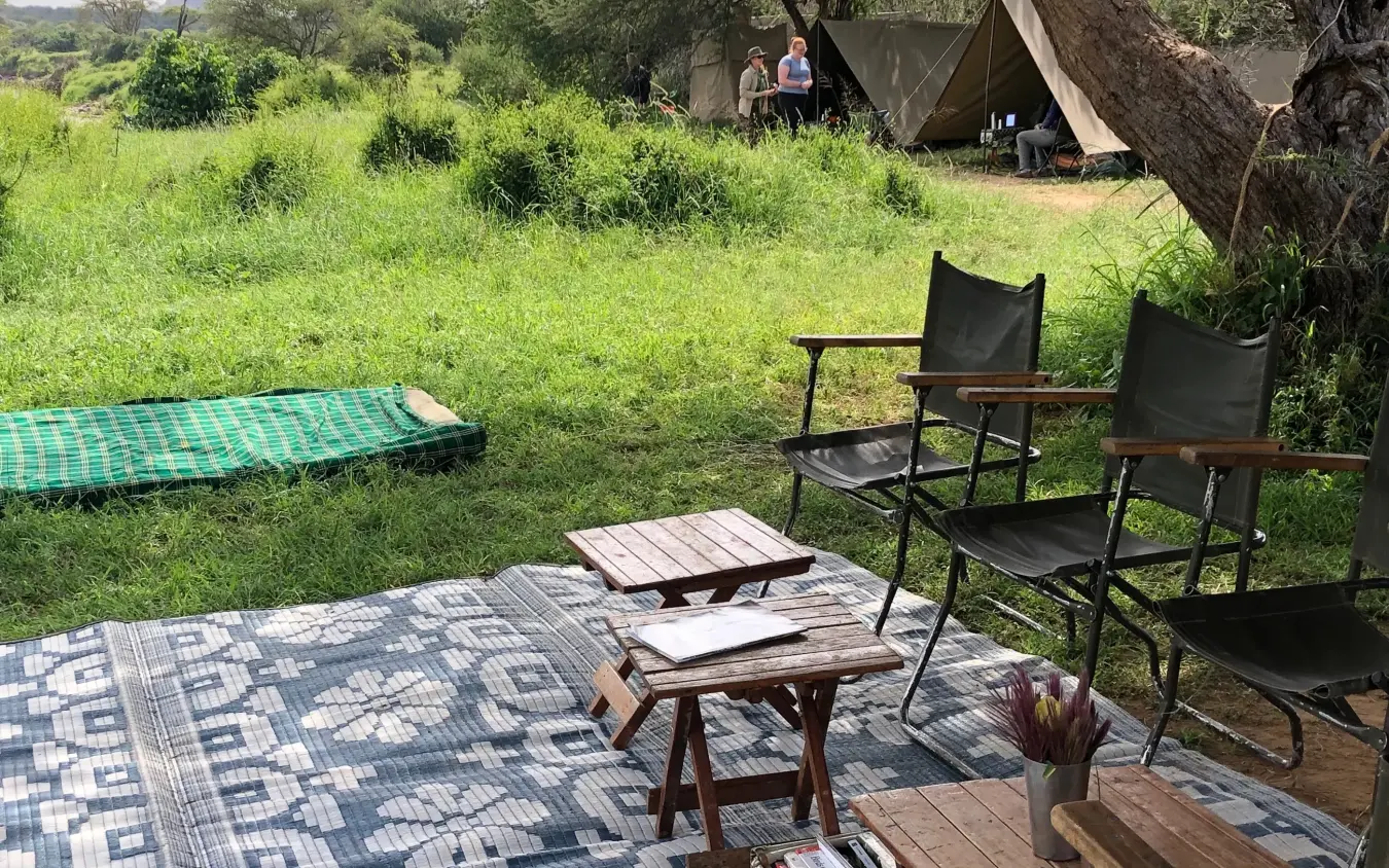 Safari camp seating area with green savanna landscape, Karisia Walking Safaris, Laikipia Highlands, Kenya