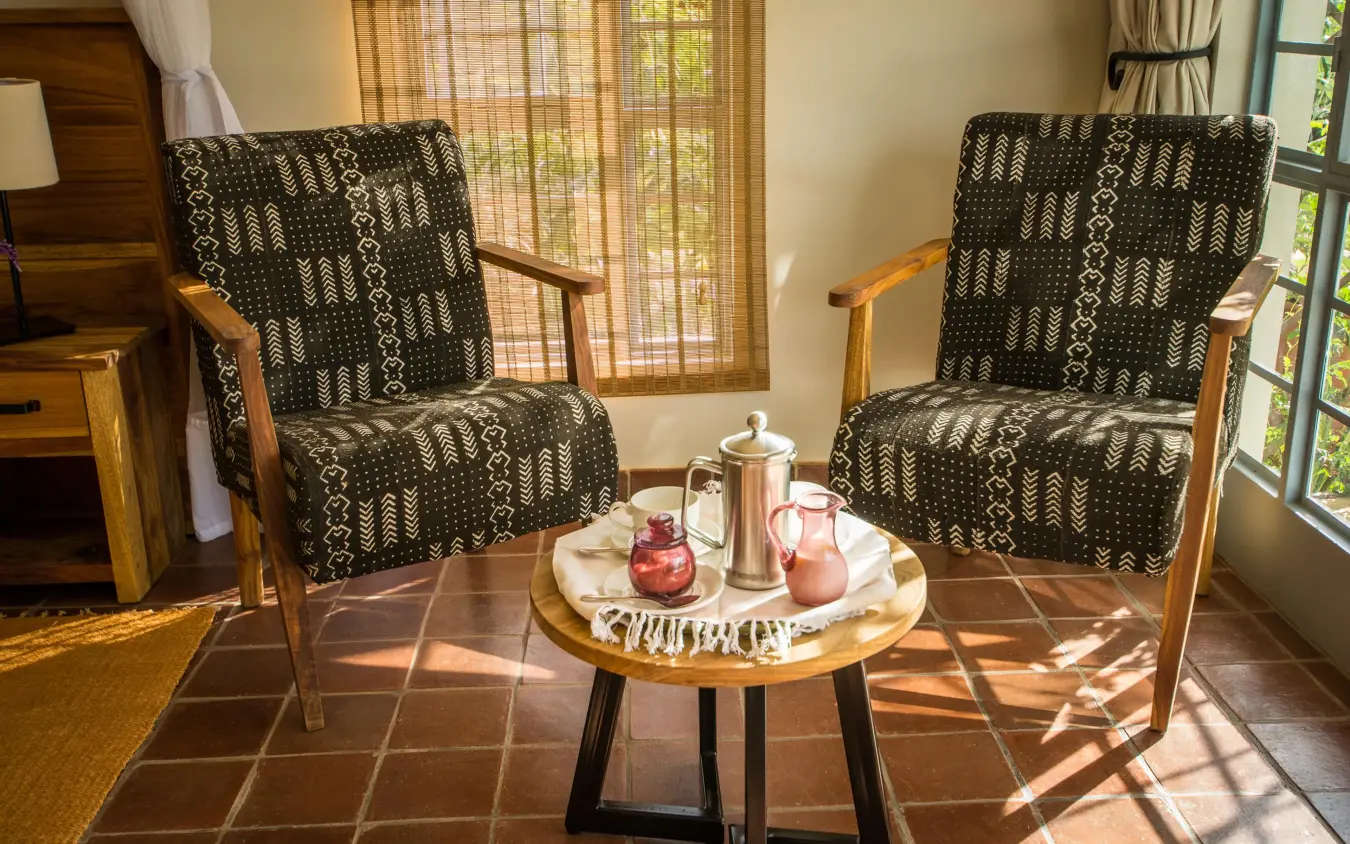 Two patterned chairs with side table and refreshments, Katambuga House, Arusha, Tanzania