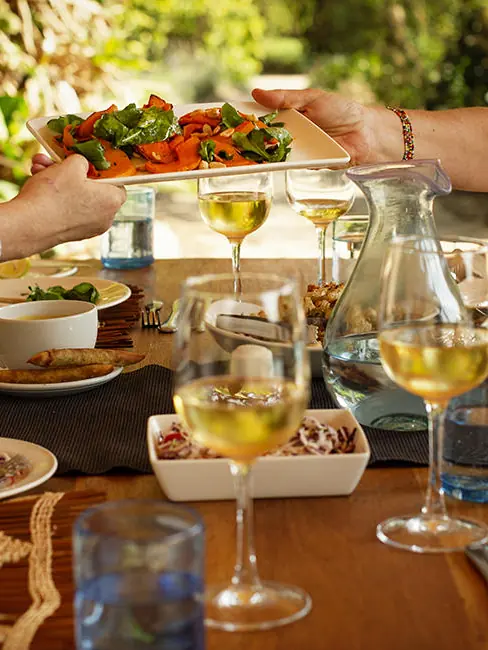 Outdoor lunch table with salad, wine, and place settings, Katambuga House, Arusha, Tanzania