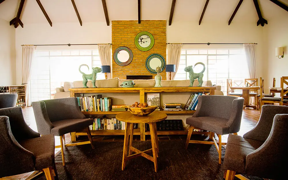 Mid-century modern lounge with comfortable seating and bookshelves, Katambuga House, Arusha, Tanzania