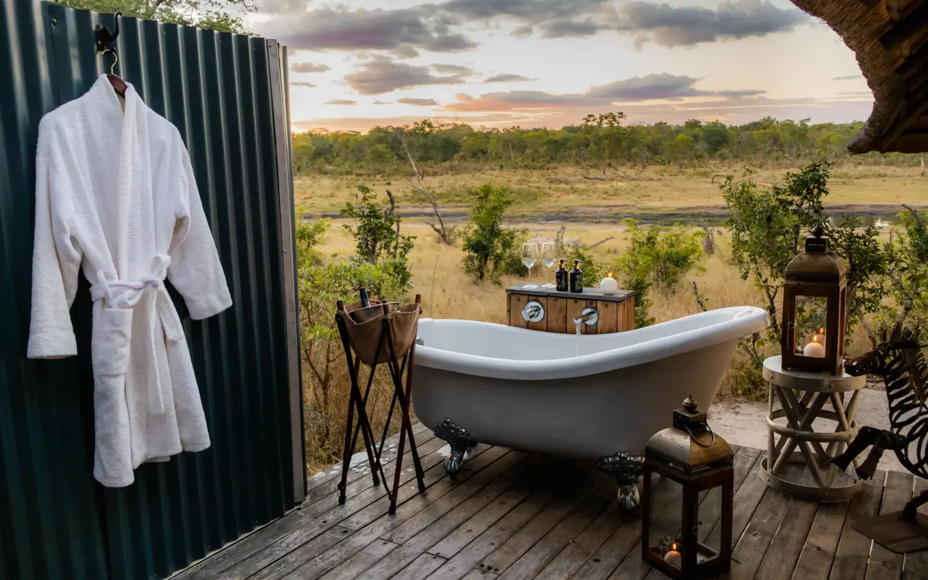 Outdoor bathtub with savanna landscape view at sunset, Khulu Bush Camp, Hwange National Park, Zimbabwe