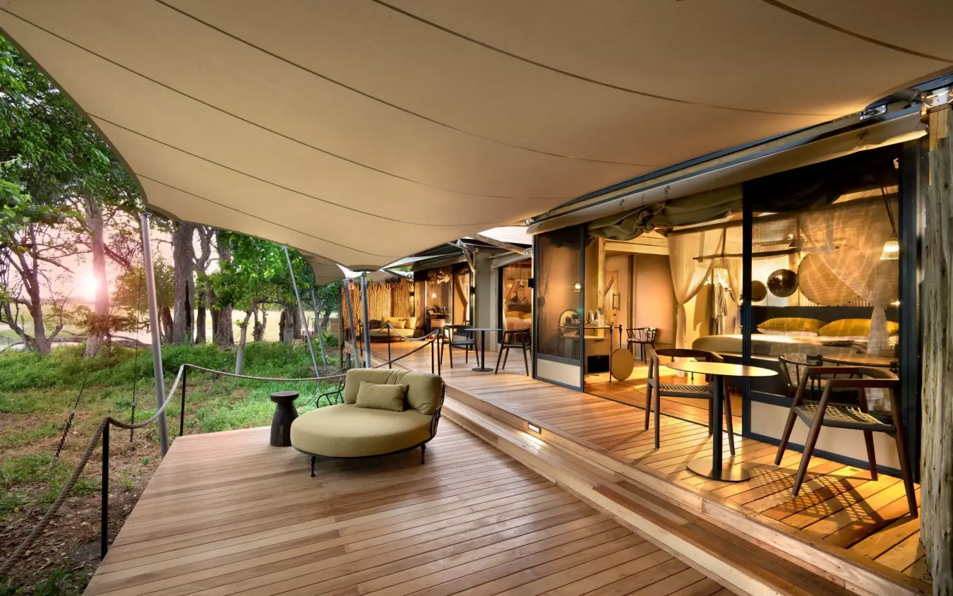 Wooden deck with seating overlooking trees at dusk, Khwai Leadwood, The Okavango Delta, Botswana