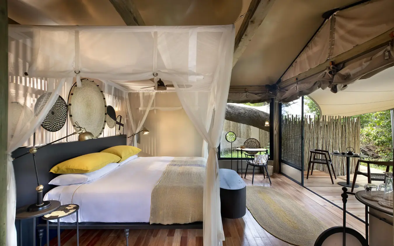 Bedroom with four-poster bed and open deck view, Khwai Leadwood, The Okavango Delta, Botswana