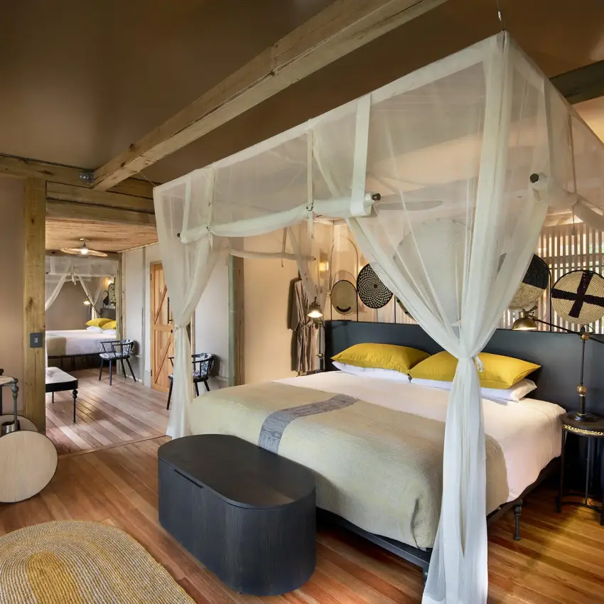 Spacious bedroom with four-poster canopy bed and wooden beams, Khwai Leadwood, The Okavango Delta, Botswana