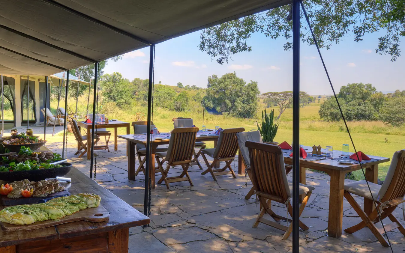Open-air dining deck overlooking grassland savanna at sunset, Kicheche Bush Olare, Maasai Mara, Kenya