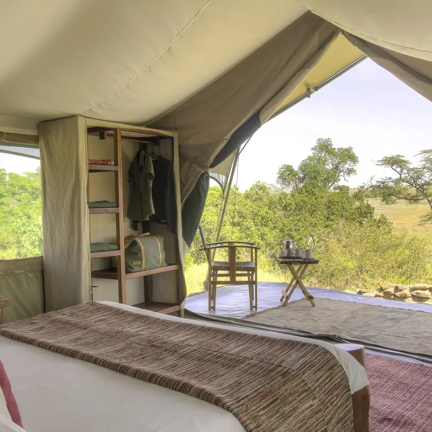 Safari tent bedroom with views of acacia trees and savanna, Kicheche Mara North, Maasai Mara, Kenya