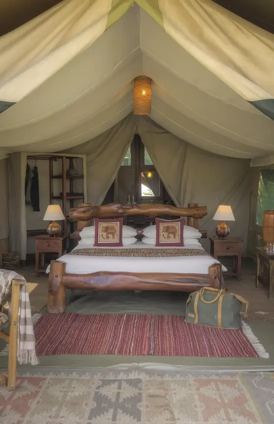Luxury safari tent interior with bed and seating area, Kicheche Mara North, Maasai Mara, Kenya