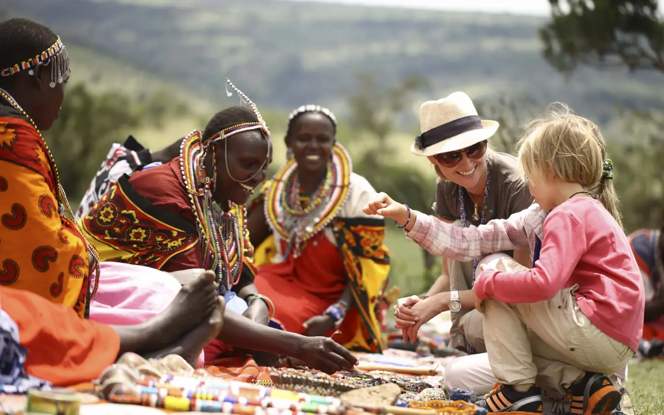 Local community members sharing crafts with visitors during cultural encounter, Kichwa Tembo Tented Camp, Maasai Mara, Kenya