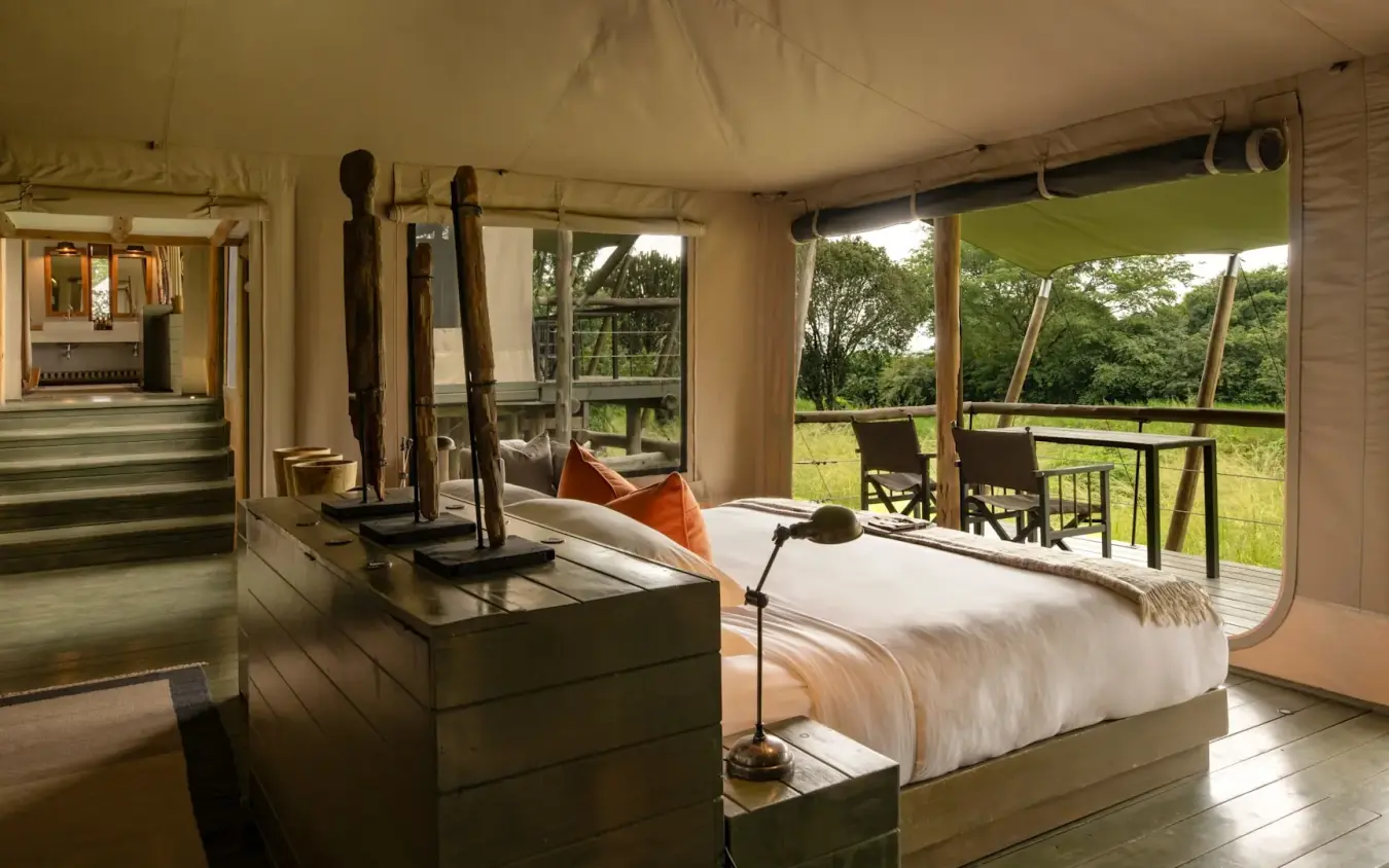 Luxury safari tent bedroom with views of grassland and acacia trees, Kichwa Tembo Tented Camp, Maasai Mara, Kenya