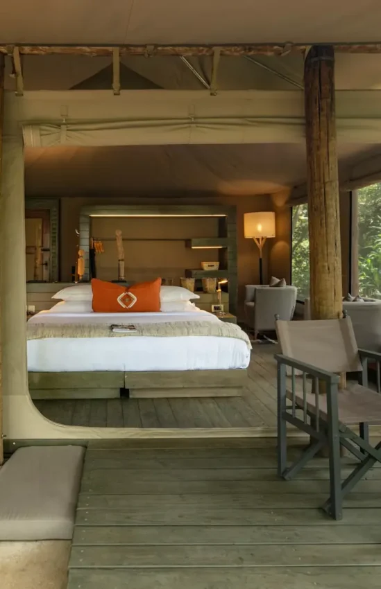 Luxury safari tent bedroom with wooden deck and lounge seating area, Kichwa Tembo Tented Camp, Maasai Mara, Kenya