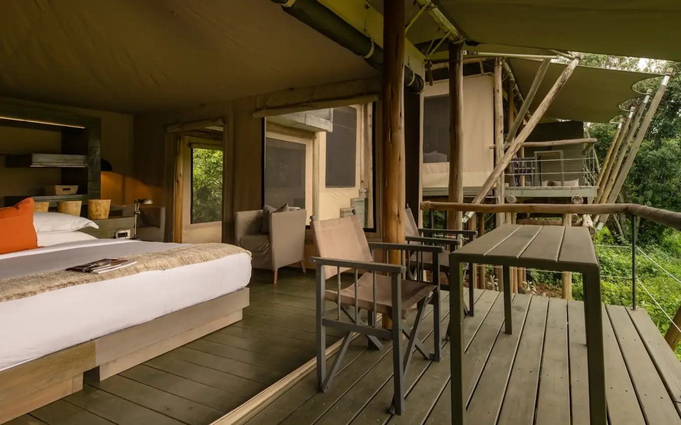 Luxury safari tent bedroom with deck overlooking woodland canopy, Kichwa Tembo Tented Camp, Maasai Mara, Kenya