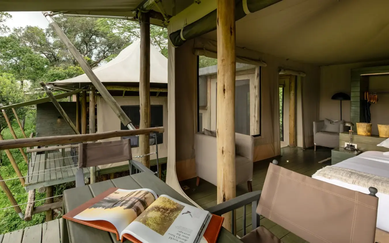Tree house bedroom deck with open-air bath overlooking forest canopy, Kichwa Tembo Tented Camp, Maasai Mara, Kenya