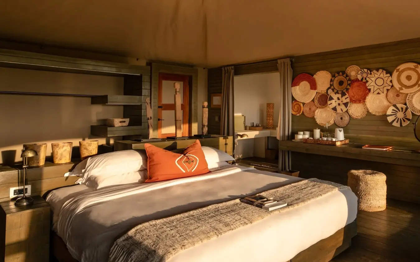Luxury bedroom interior with woven basket wall art and African-inspired decor, Kichwa Tembo Tented Camp, Maasai Mara, Kenya