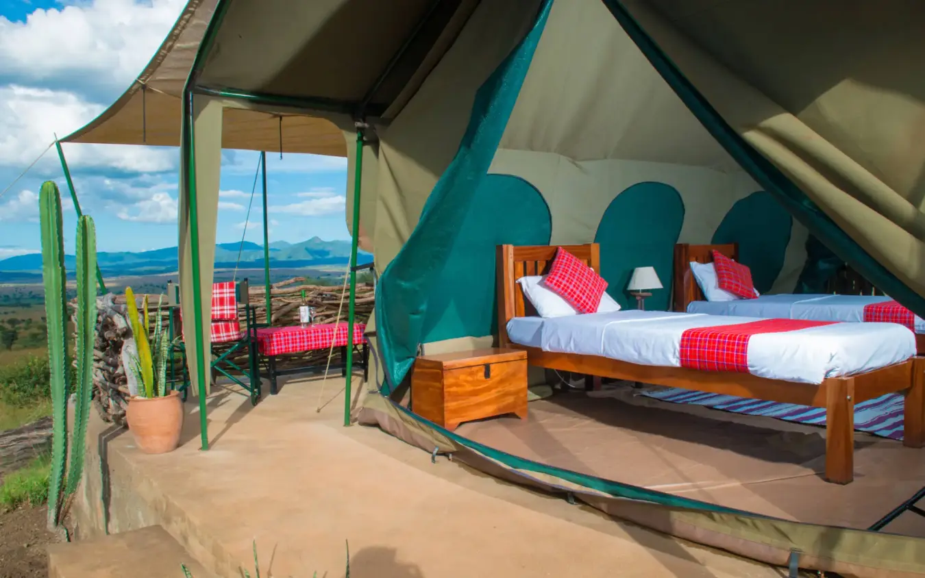 Safari tent bedroom with beds and savanna landscape view, Kidepo Savannah Lodge, Kidepo Valley, Uganda