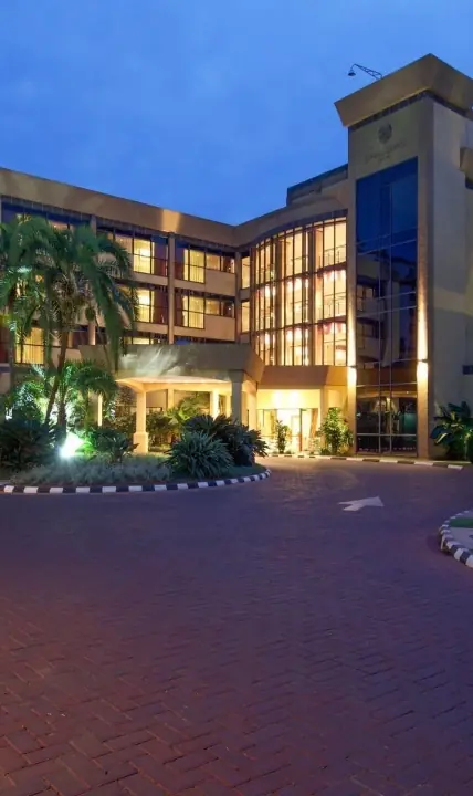 Modern hotel building lit at dusk with palm trees, Kigali Serena Hotel, Kigali, Rwanda