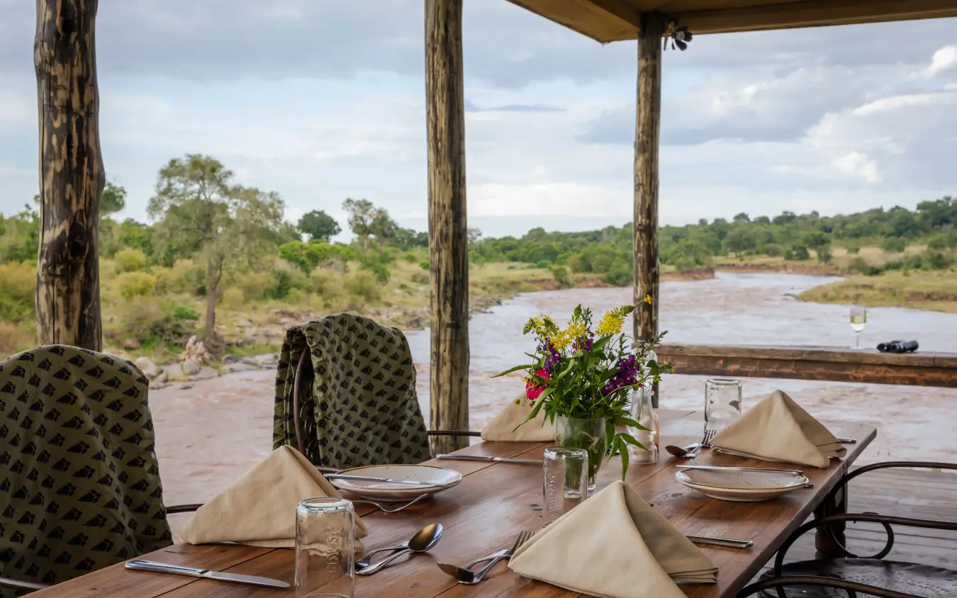 Dining deck overlooking river with savanna landscape, Kimya Kimya Camp, Maasai Mara, Kenya