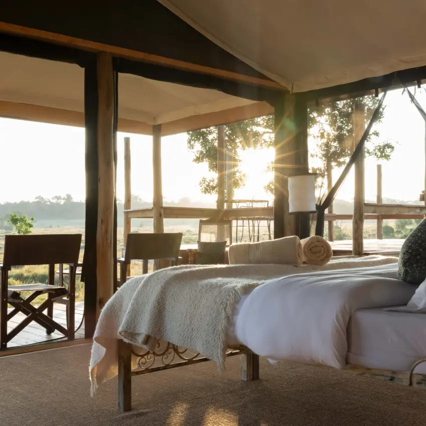 Safari bedroom with bed overlooking river and landscape, Kimya Kimya Camp, Maasai Mara, Kenya