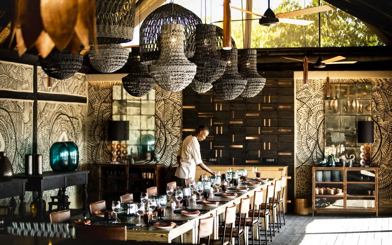 Elegant dining room with hanging pendant lights and patterned walls, King’s Pool, Linyanti Wildlife Reserve, Botswana