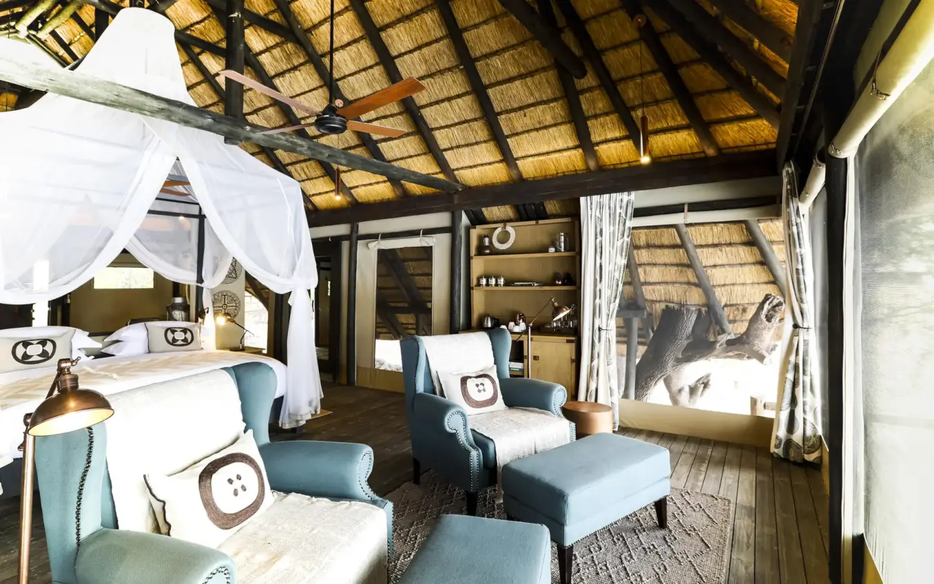 Luxury bedroom with canopy bed and thatched roof interior, King’s Pool, Linyanti Wildlife Reserve, Botswana