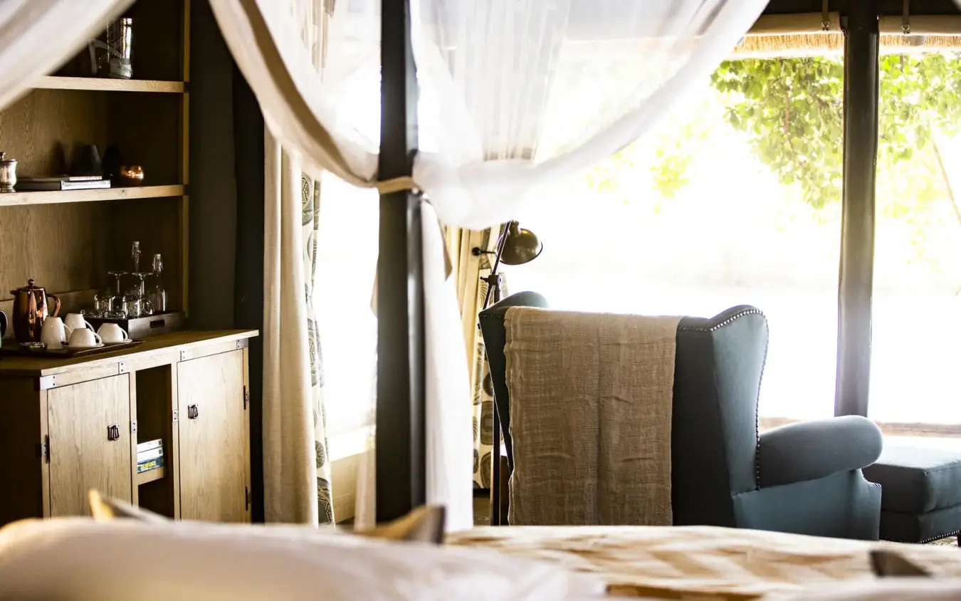 Luxury bedroom with four-poster bed and natural light, King’s Pool, Linyanti Wildlife Reserve, Botswana