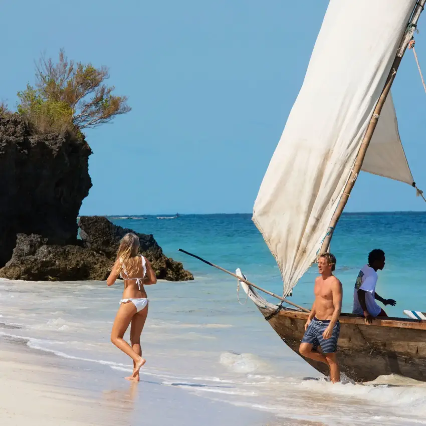 Traditional sailing dhow with guests on tropical beach, Kinondo Kwetu, Diani Beach, Kenya