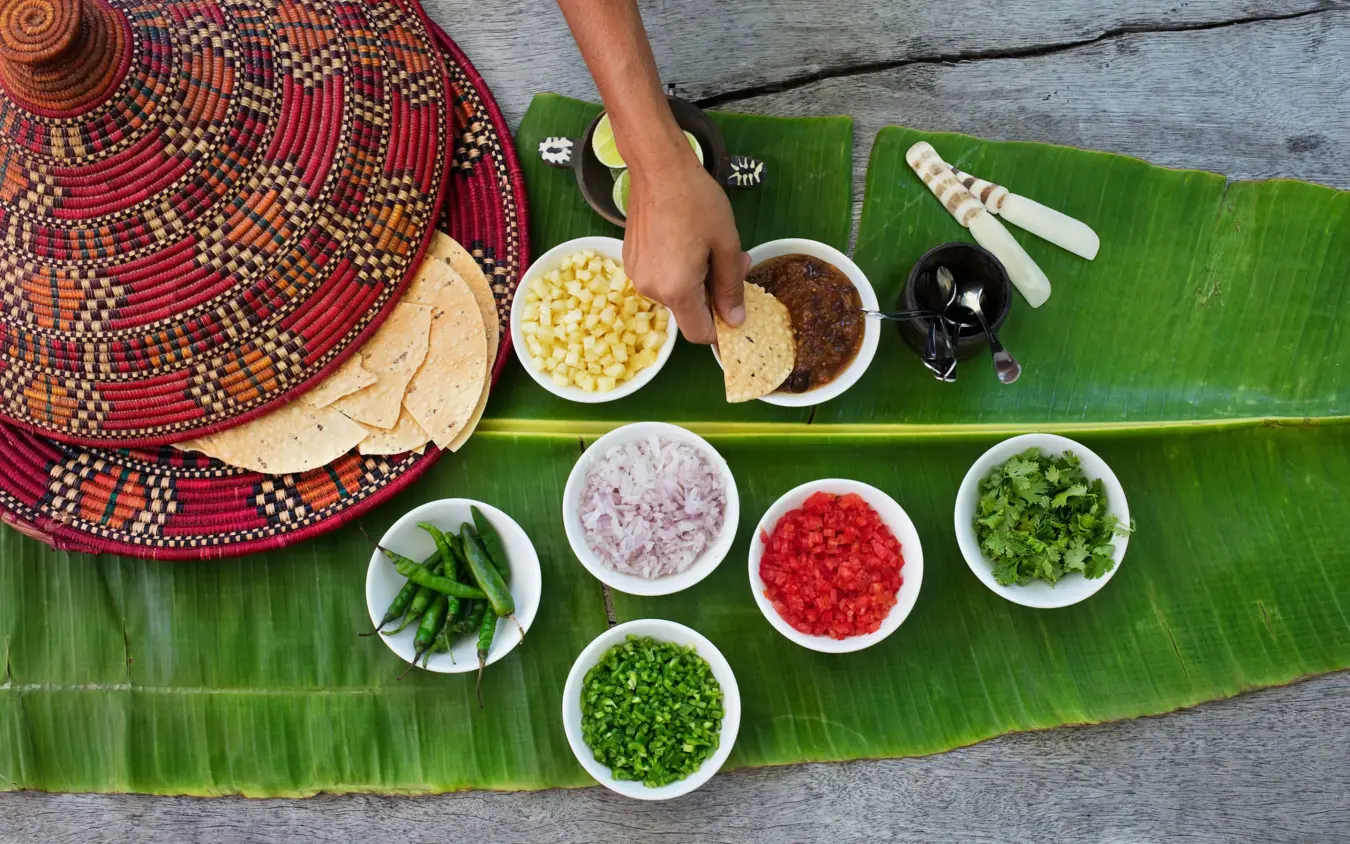 Traditional beaded clothing with prepared ingredients on banana leaf, Kinondo Kwetu, Diani Beach, Kenya