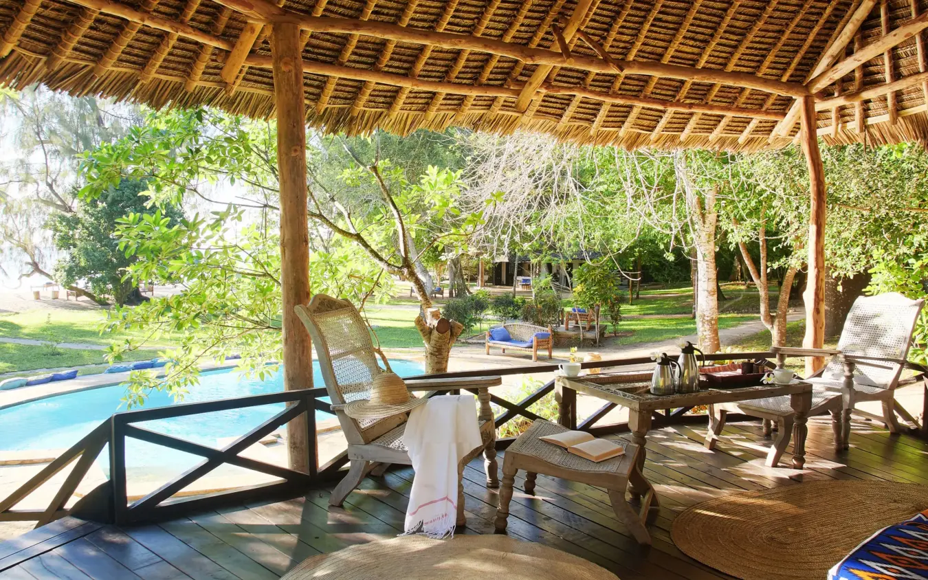 Thatched pavilion with lounge seating overlooking swimming pool and gardens, Kinondo Kwetu, Diani Beach, Kenya
