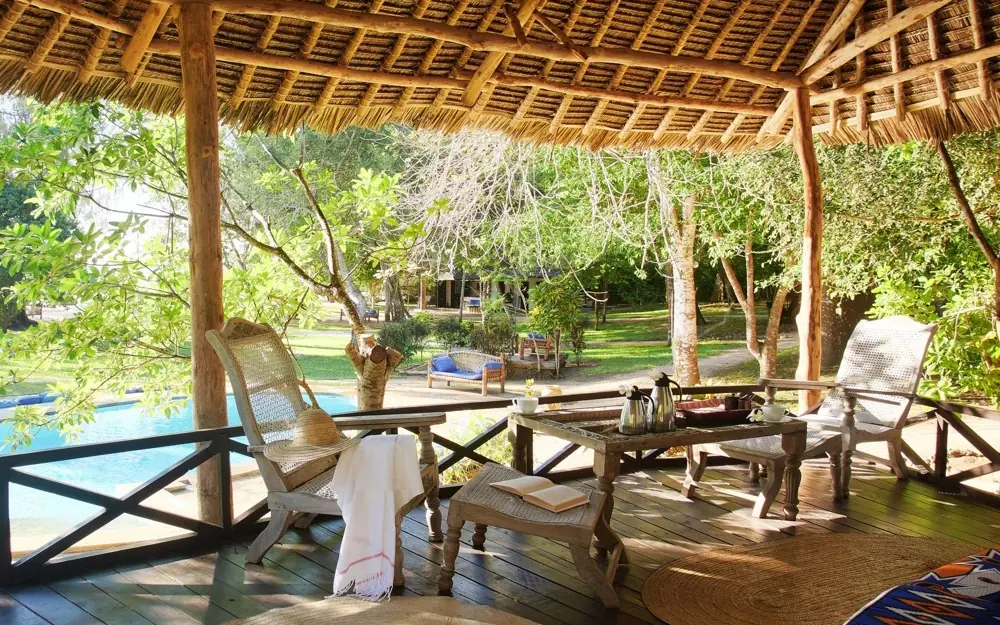 Thatched pavilion with lounge seating overlooking tropical gardens and pool, Kinondo Kwetu, Diani Beach, Kenya