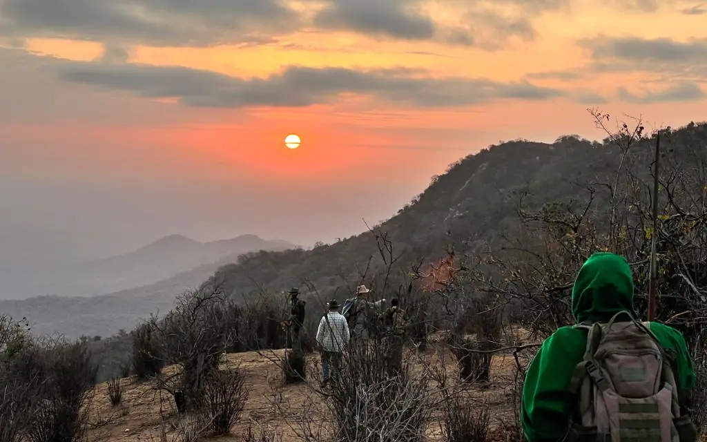 Hikers with backpacks on mountain trail at sunset, Kitich Camp, Northern Kenya, Kenya