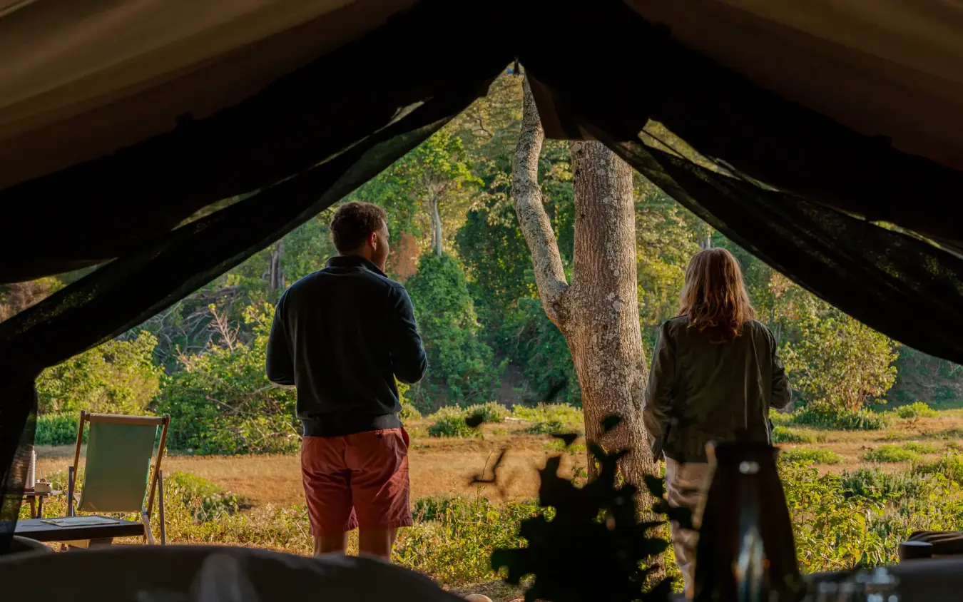 Guests viewing landscape from tent entrance at camp, Kitich Camp, Northern Kenya, Kenya