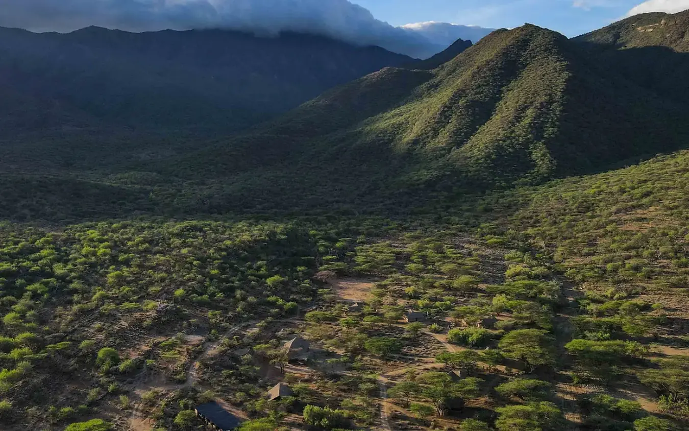 Volcanic landscape with sparse vegetation and distant mountains, Koros Camp, Northern Kenya, Kenya