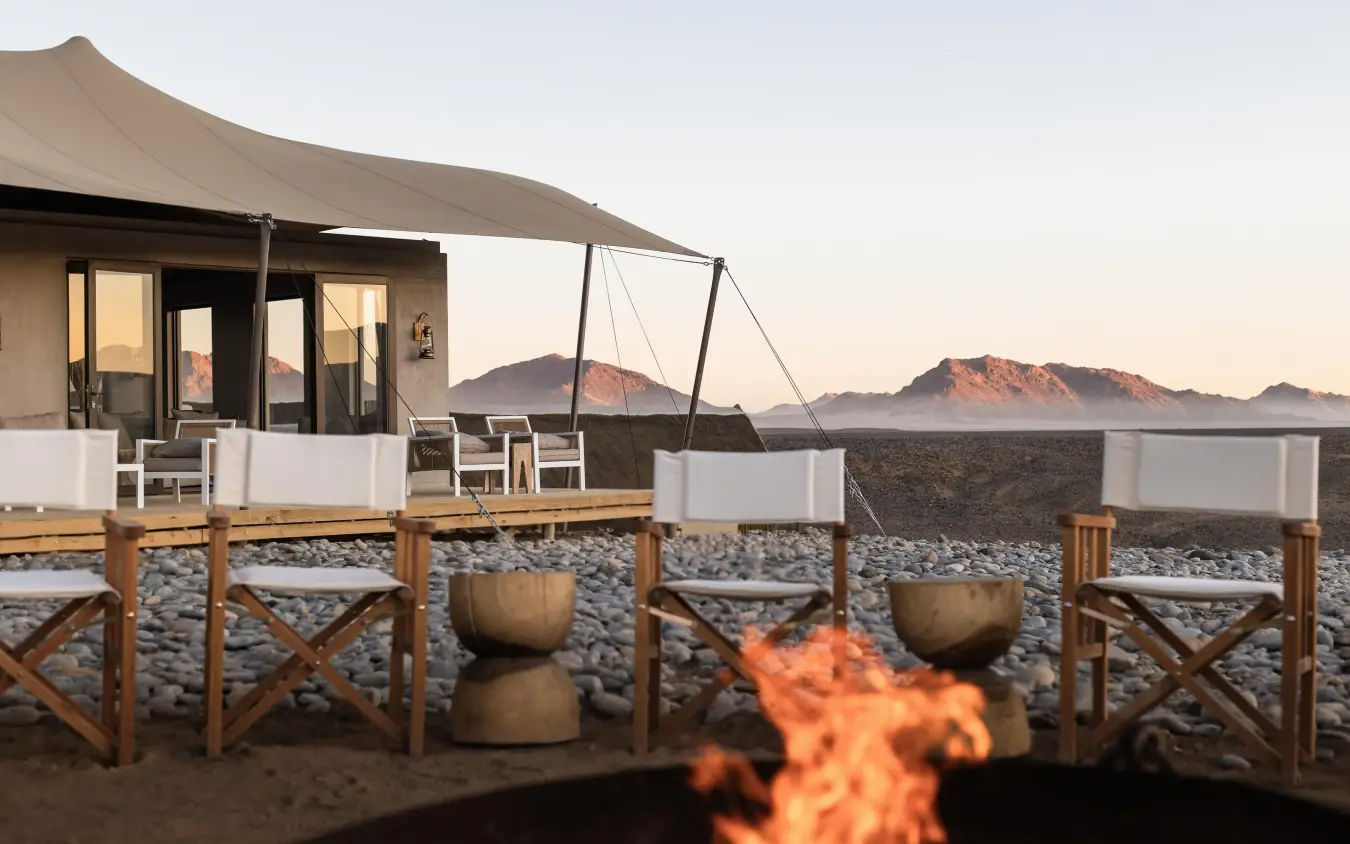 Desert lodge deck with firepit and mountain views at dusk, Kulala Desert Lodge, Sossusvlei, Namibia