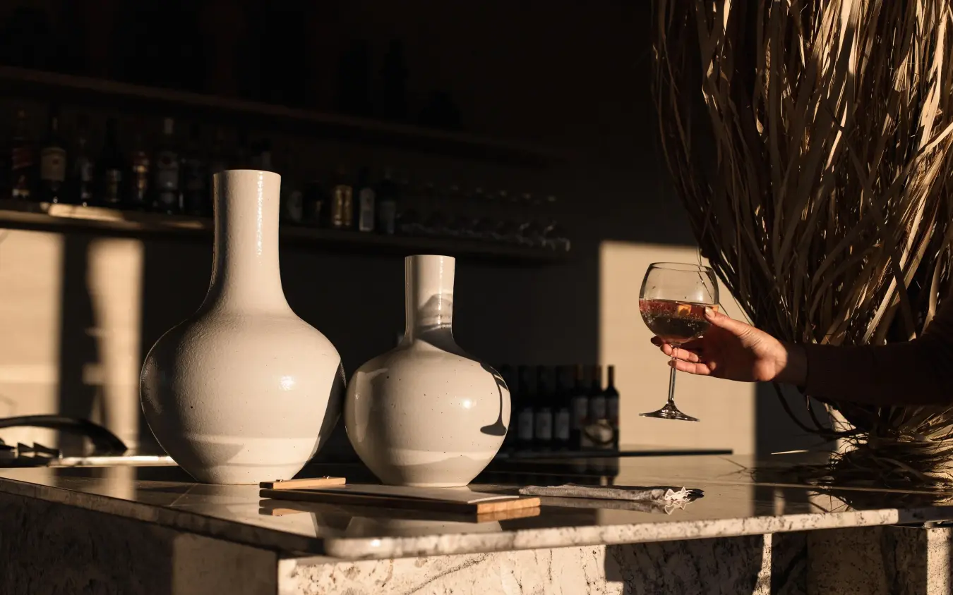 White ceramic vessels and wine glass on marble table, Kulala Desert Lodge, Sossusvlei, Namibia