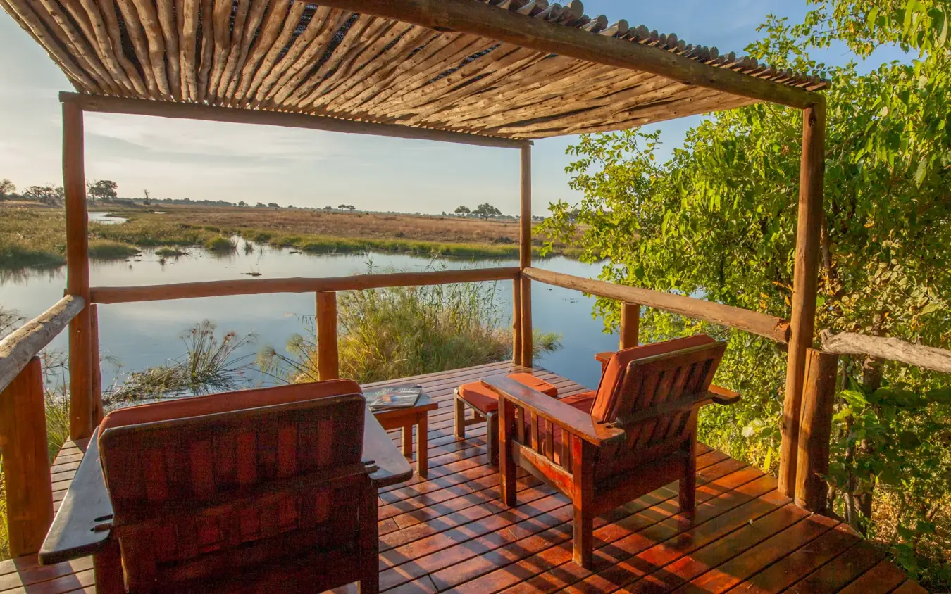 Wooden viewing deck with chairs overlooking wetland and waterbirds, Kwando Lagoon Camp, Linyanti Wildlife Reserve, Botswana