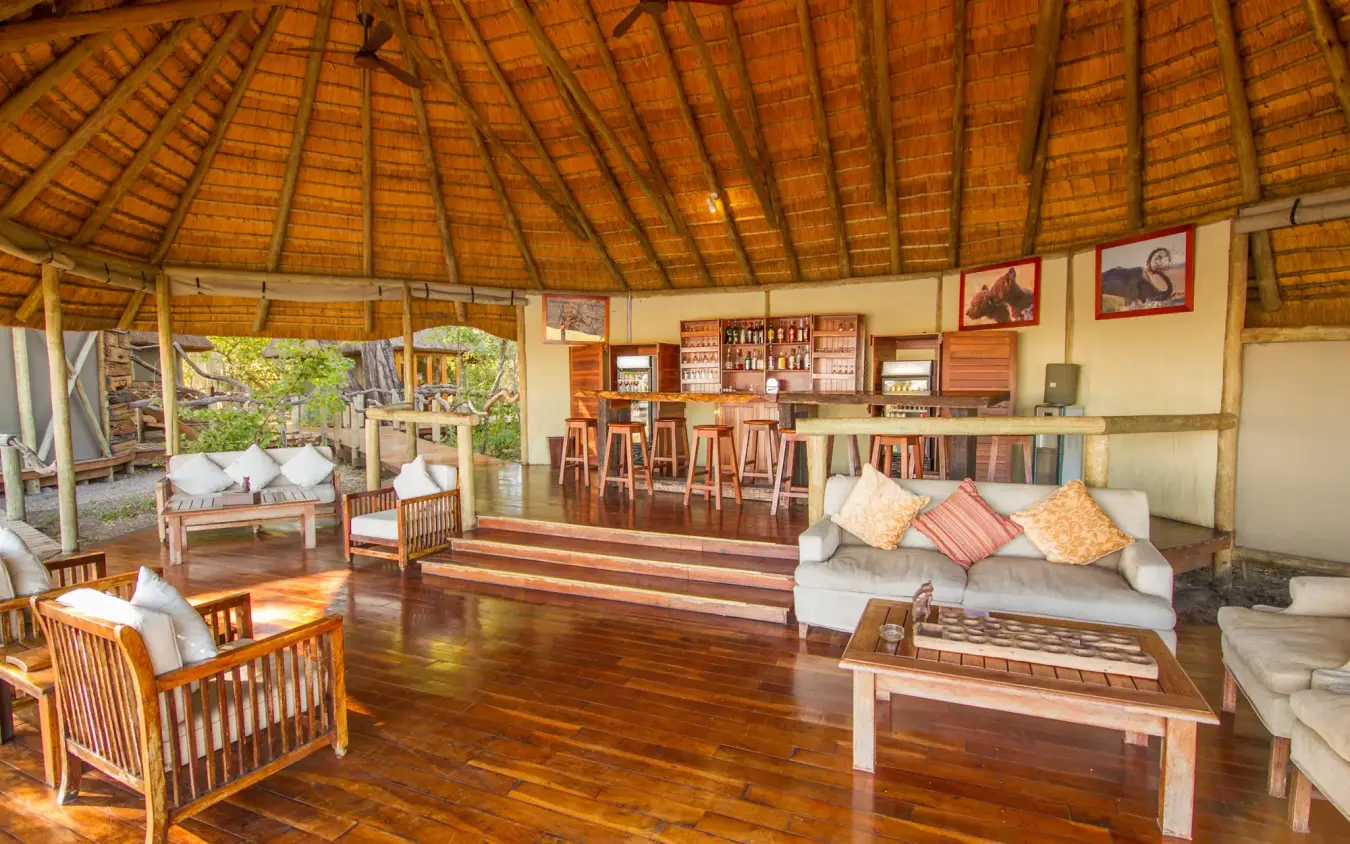 Open-sided lodge interior with wooden furnishings and thatched roof, Kwando Lagoon Camp, Linyanti Wildlife Reserve, Botswana