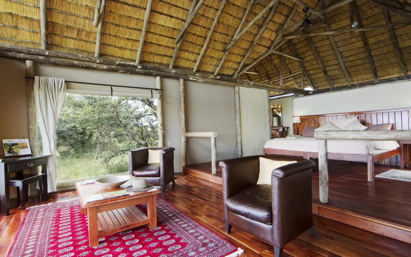 Spacious safari lodge suite with thatch roof and savanna views, Kwando Lagoon Camp, Linyanti Wildlife Reserve, Botswana