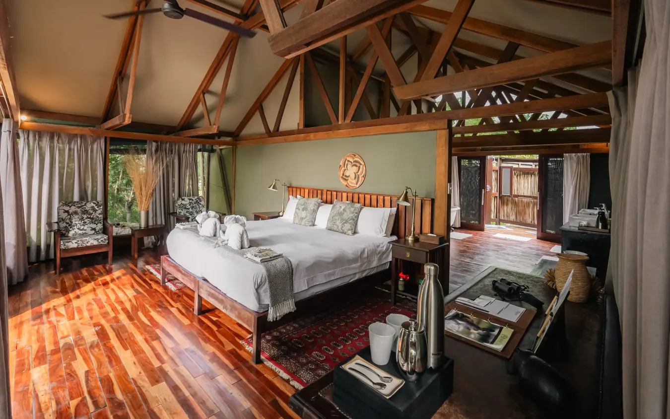 Luxury safari bedroom with wooden beams and open-air terrace, Kwando Lebala Camp, Linyanti Wildlife Reserve, Botswana