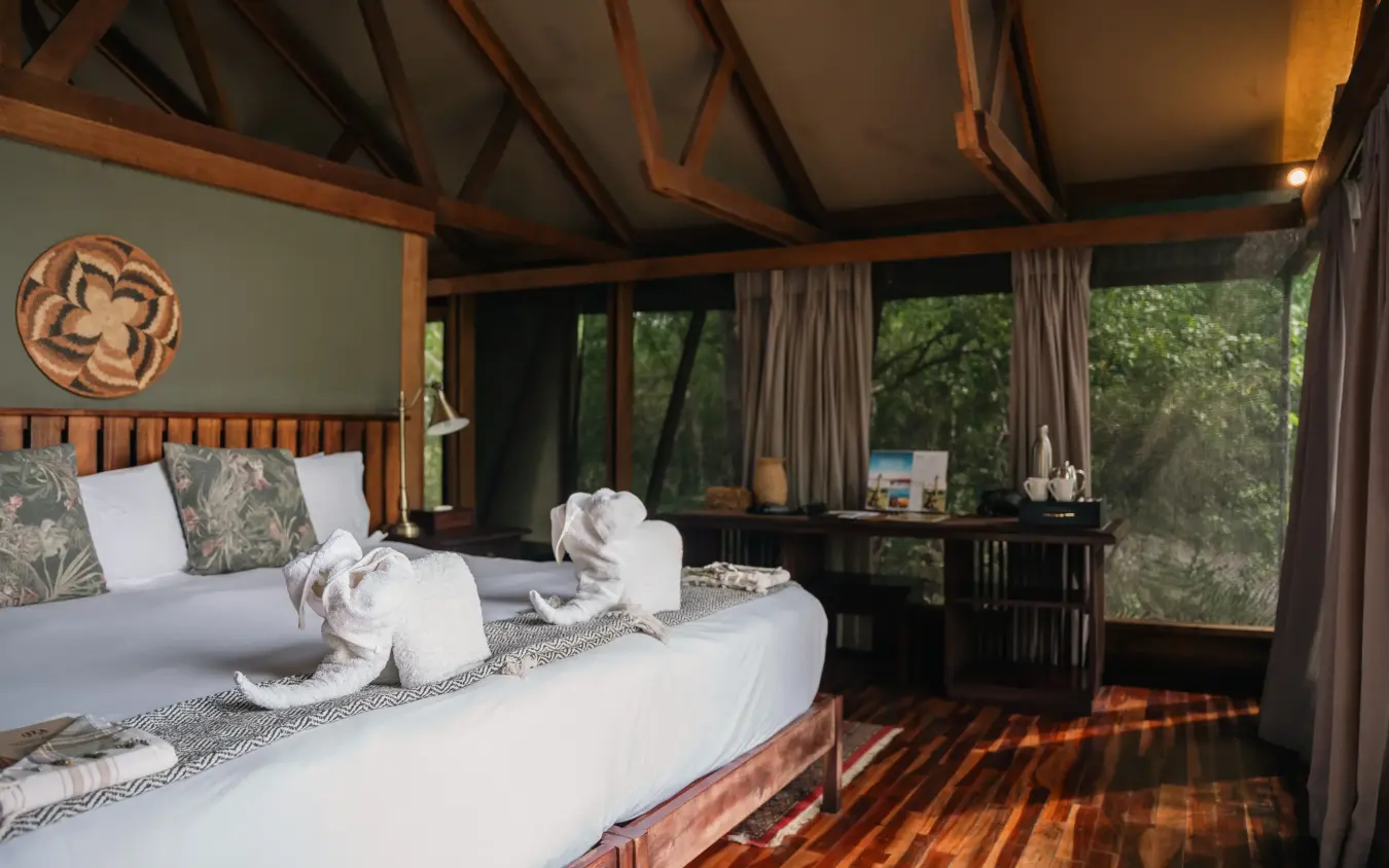 Luxury safari bedroom with wooden beams overlooking forest landscape, Kwando Lebala Camp, Linyanti Wildlife Reserve, Botswana