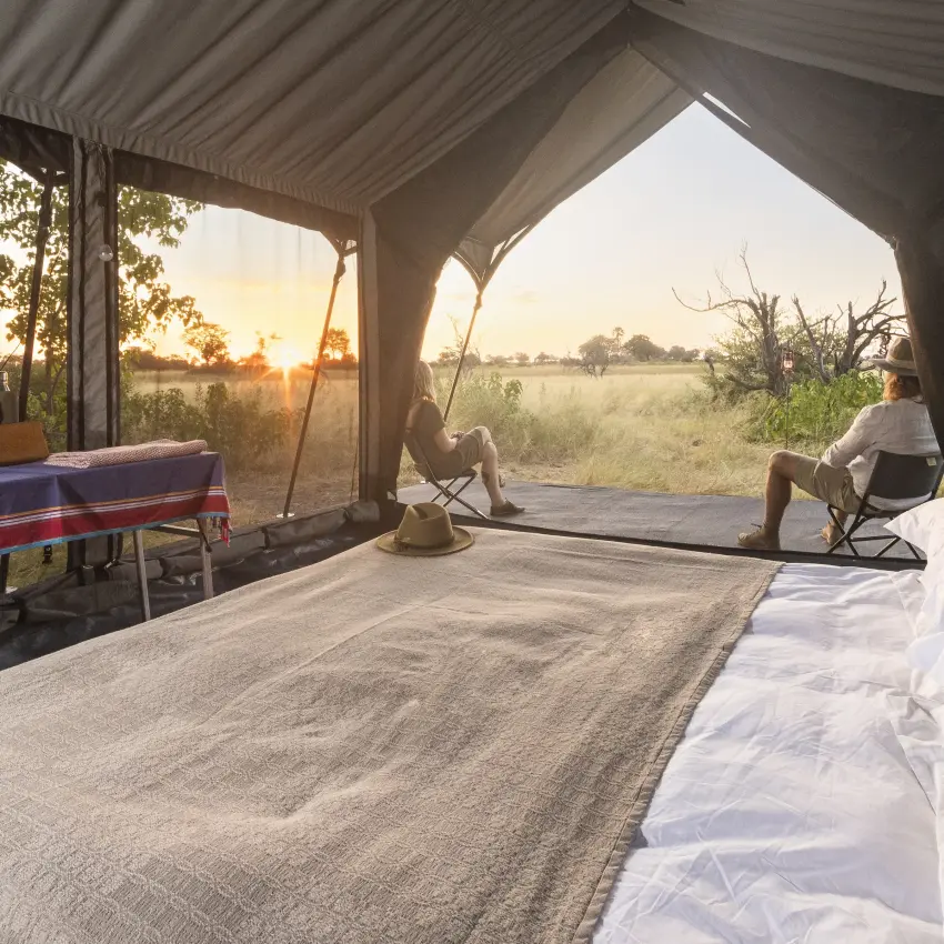 Safari tent interior with beds overlooking savanna landscape, Kweene Trails, The Okavango Delta, Botswana